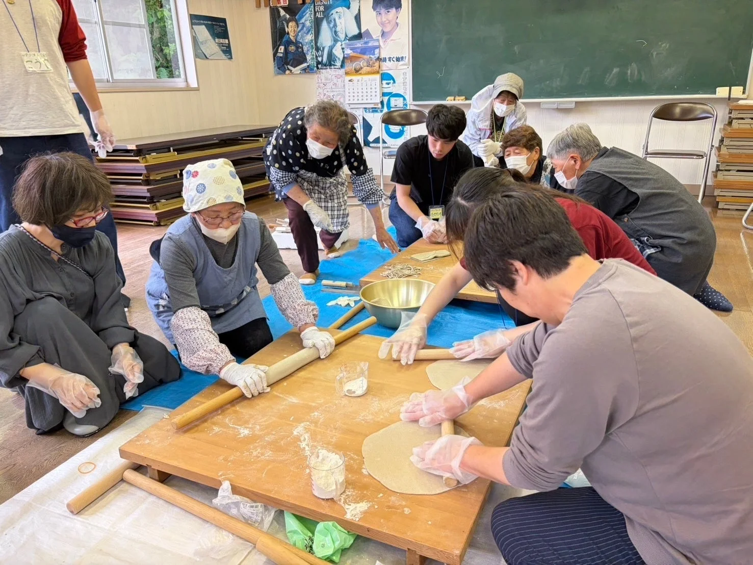 蕎麦打ち体験をする高齢者と若者