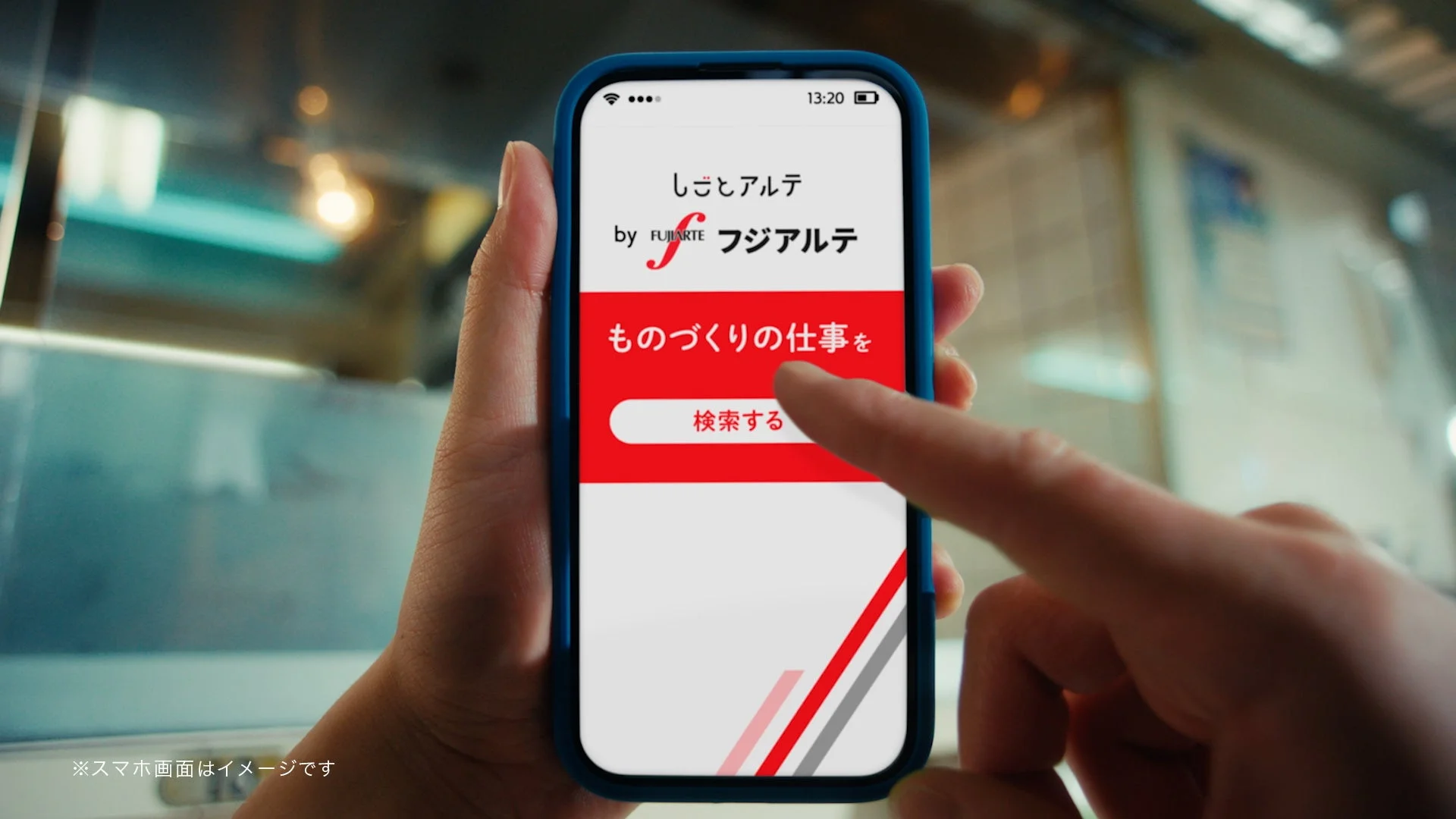 手がスマートフォンを持ち、製造業に特化した求人アプリ「しごとアルテ by FUJIARTE」の画面を操作している様子。画面には「ものづくりの仕事を検索する」と表示されています。