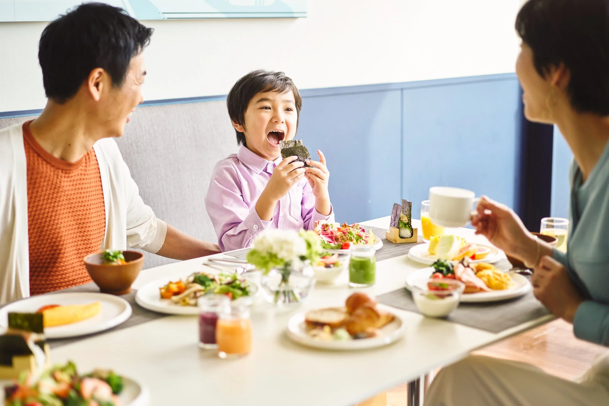 食卓を囲み楽しそうに食事をする家族
