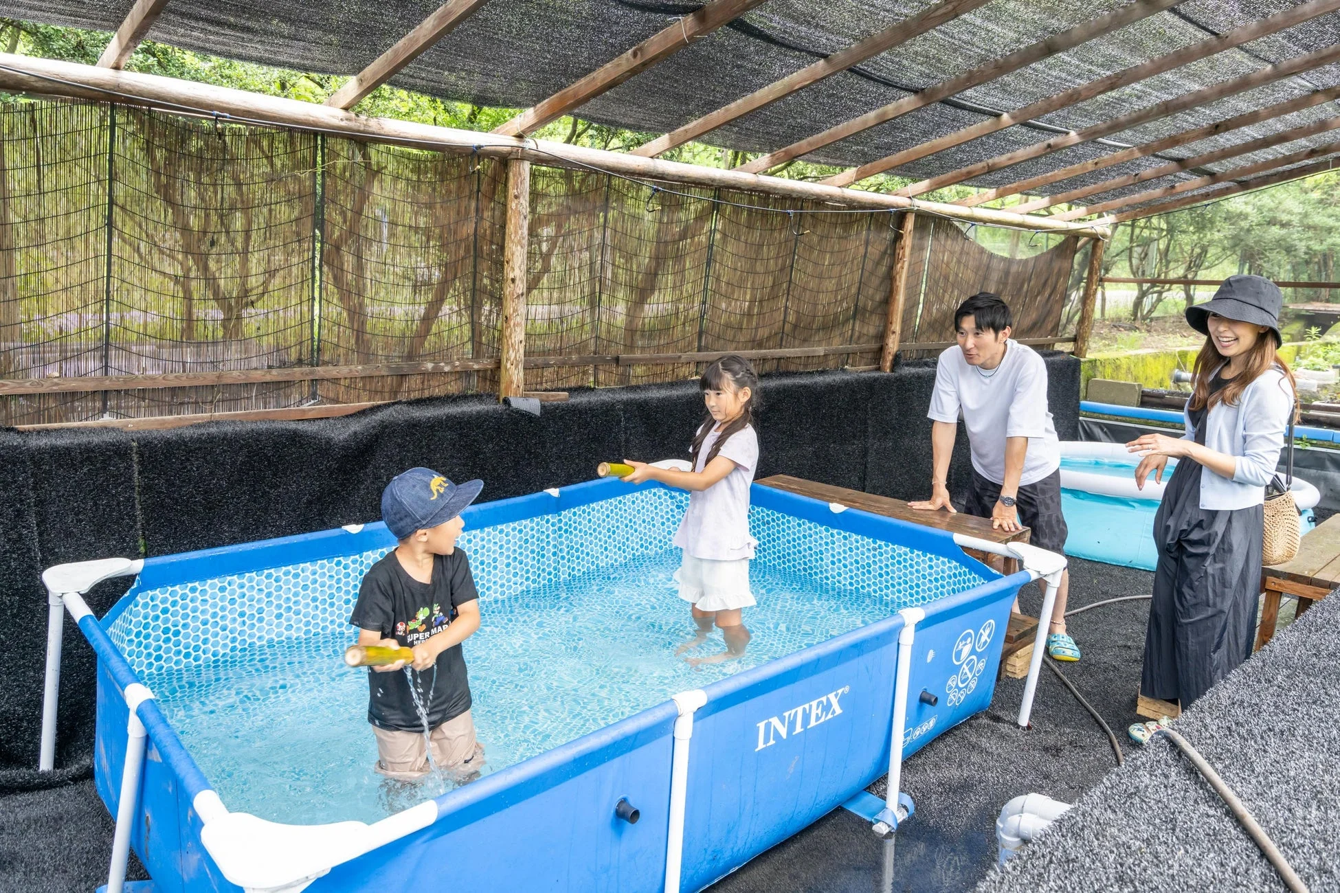 プールで水遊びを楽しむ家族