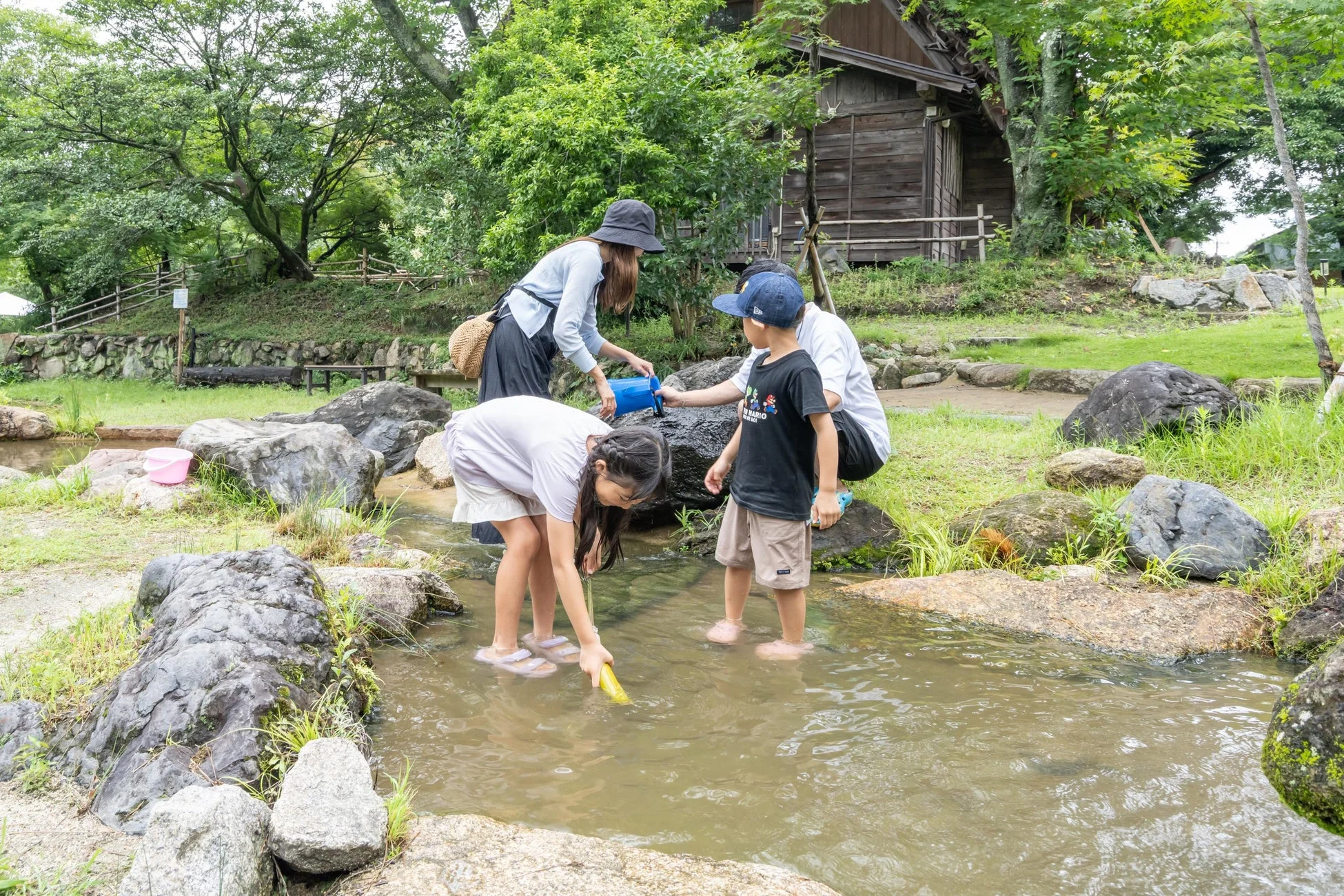 小川で水遊びをする家族