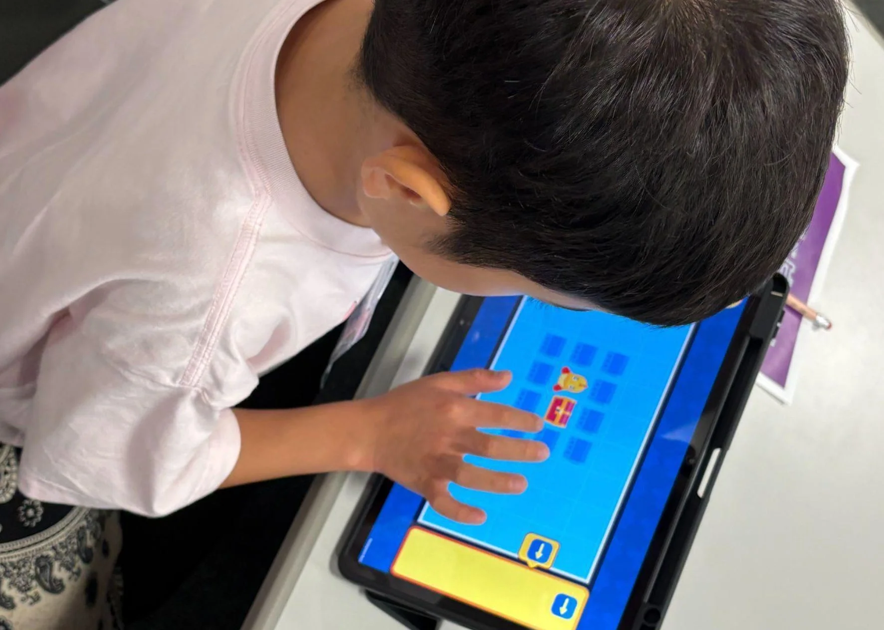 タブレットでゲームを操作する子ども