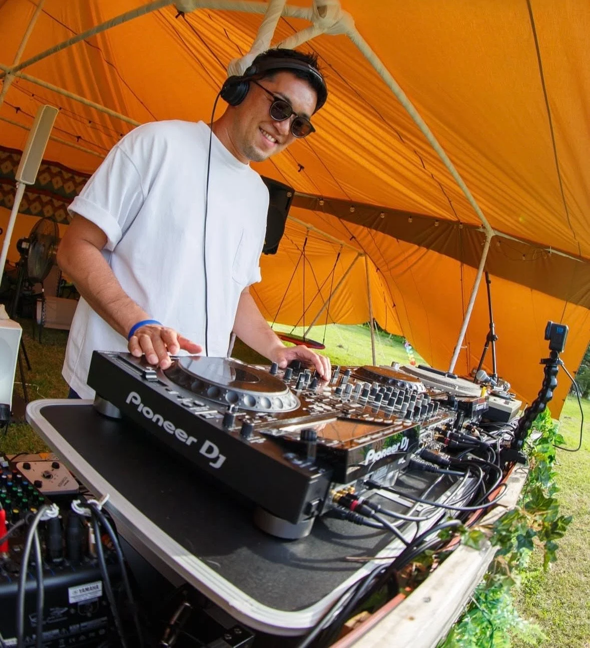 オレンジ色のテントの下でDJがプレイしている様子
