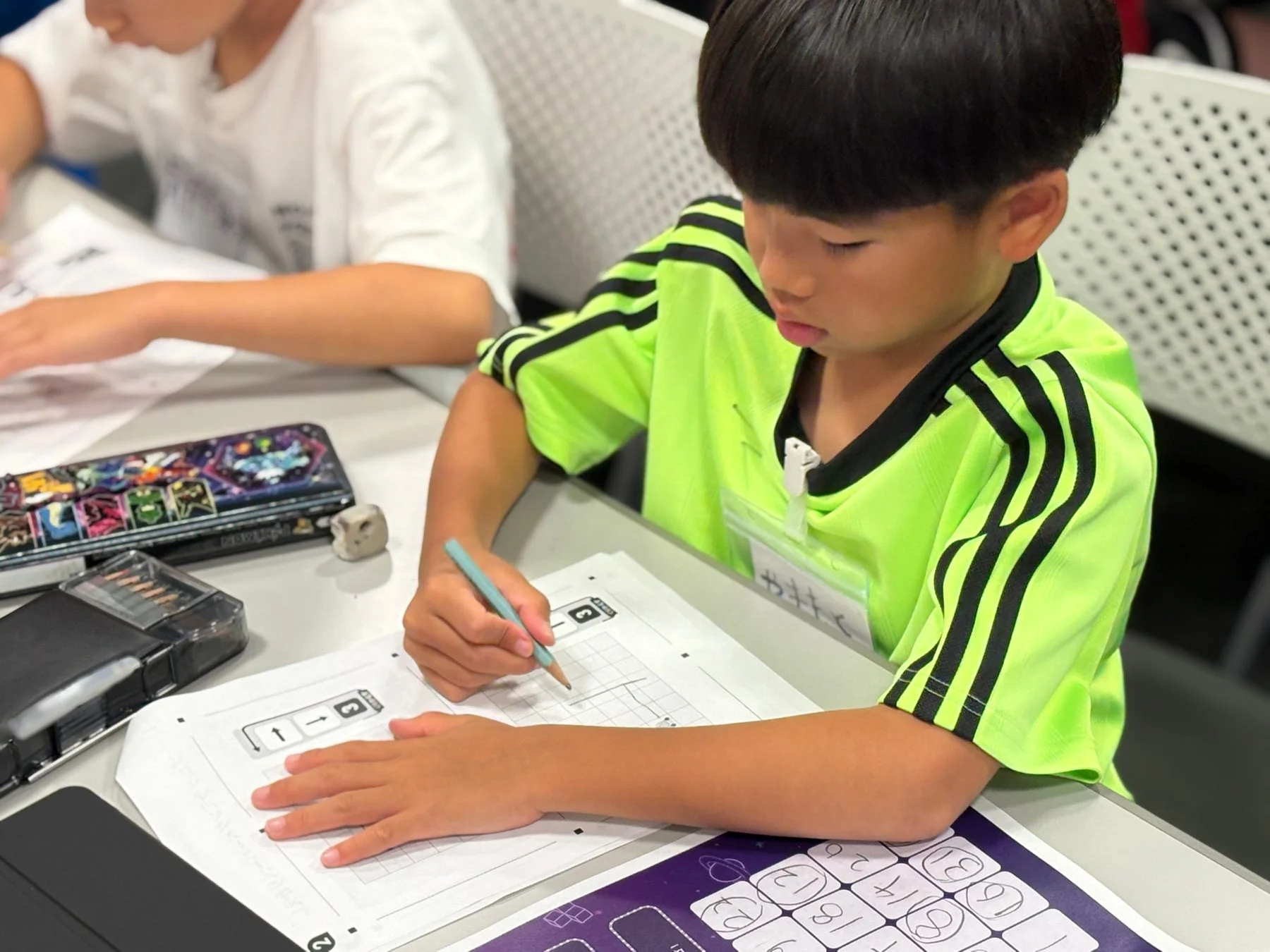 プログラミングペーパーに取り組む少年