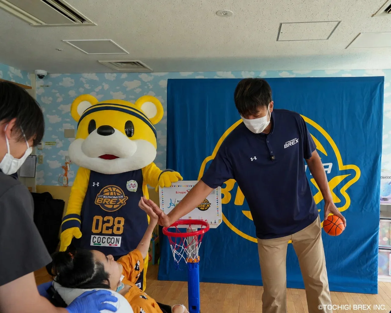 車椅子の子どもとミニゴールで交流する竹内選手とブレッキー