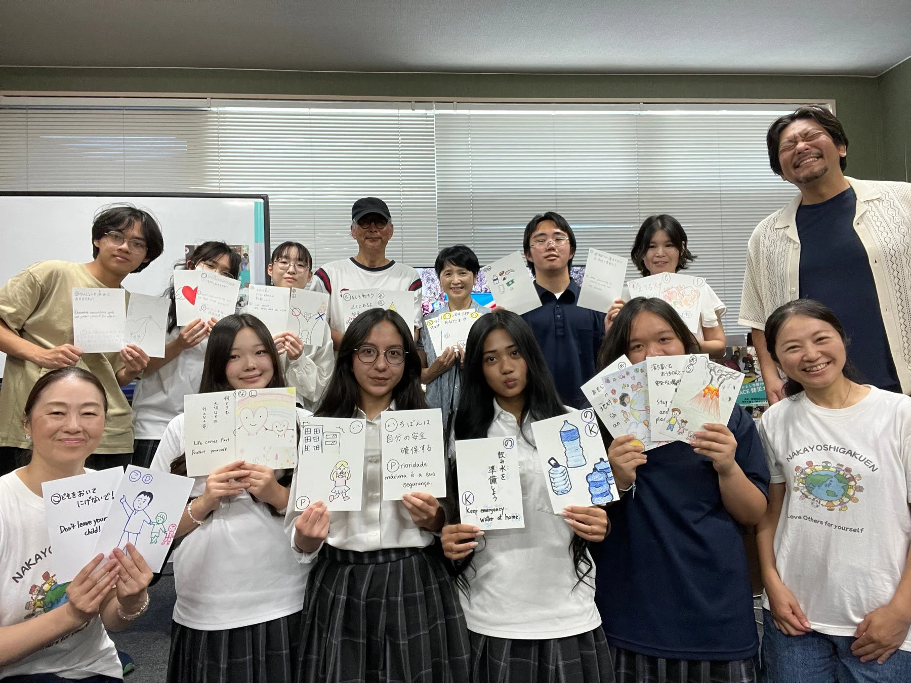防災カルタを手に笑顔で写る参加者たち
