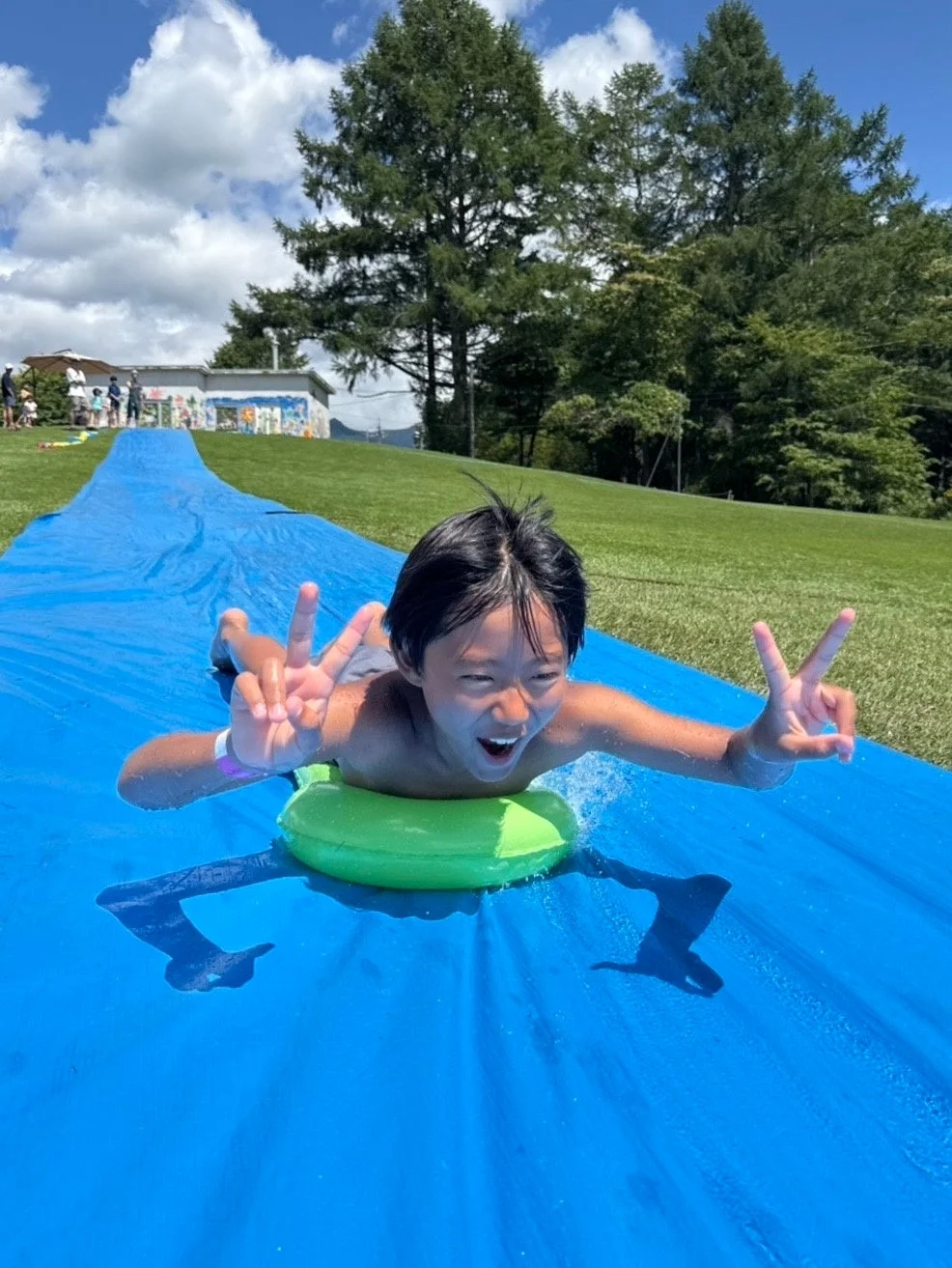 ウォータースライダーで遊ぶ少年