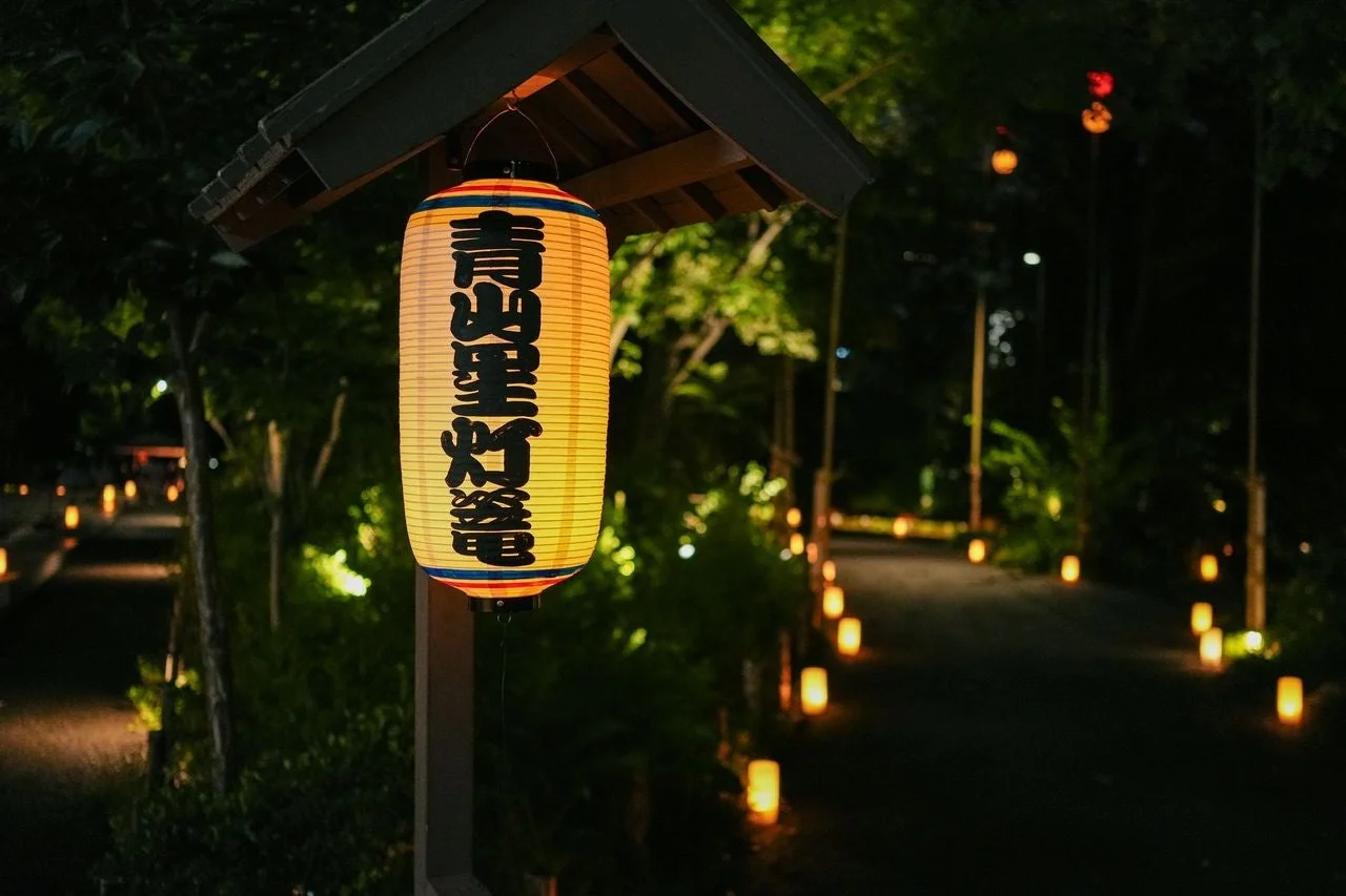 夜の日本の風景で、提灯が吊るされ道を照らしている