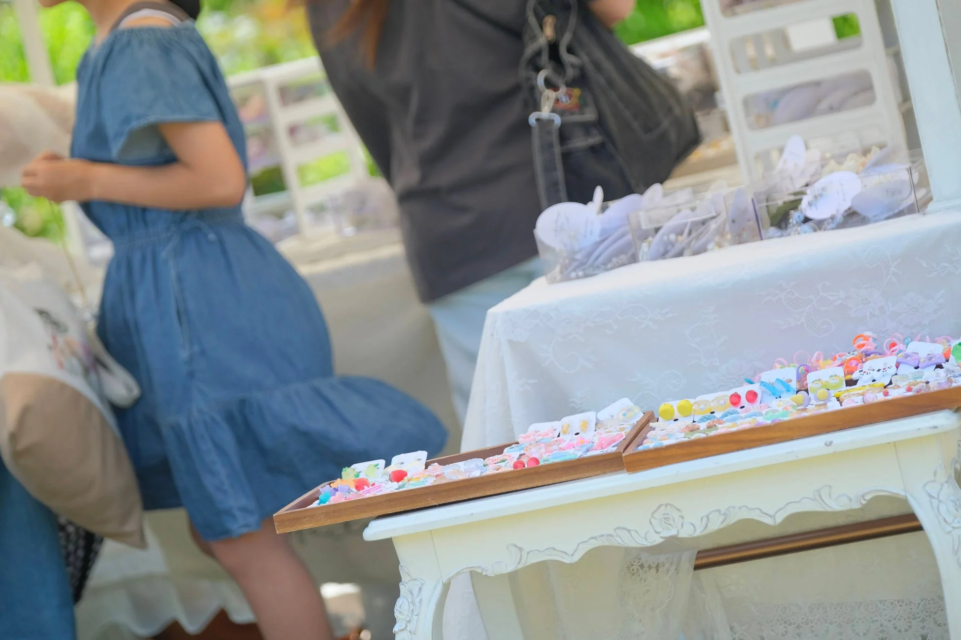 屋外イベントで、カラフルなハンドメイドアクセサリーが並べられたブースの様子