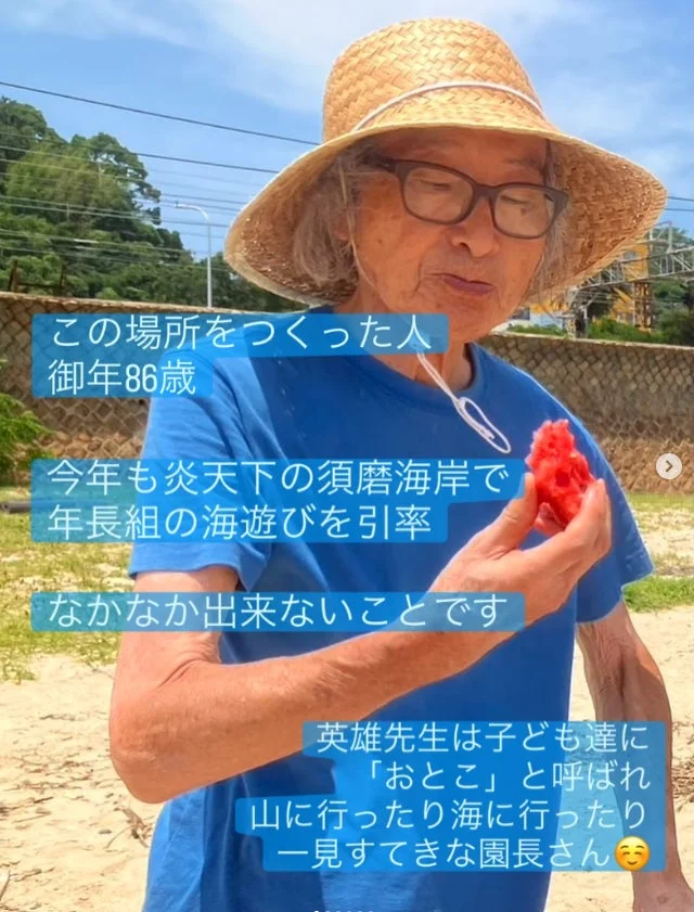 86歳の園長先生が炎天下の須磨海岸で年長組の海遊びを引率している様子