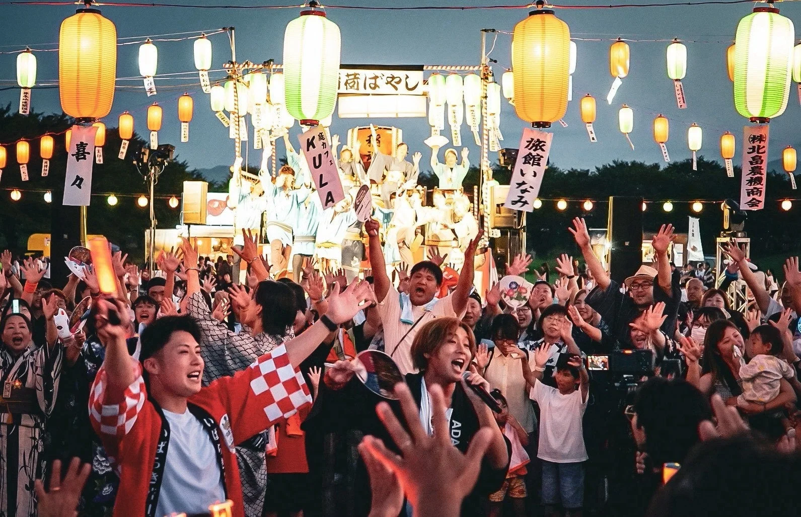 夜の夏祭りの観客とパフォーマンス
