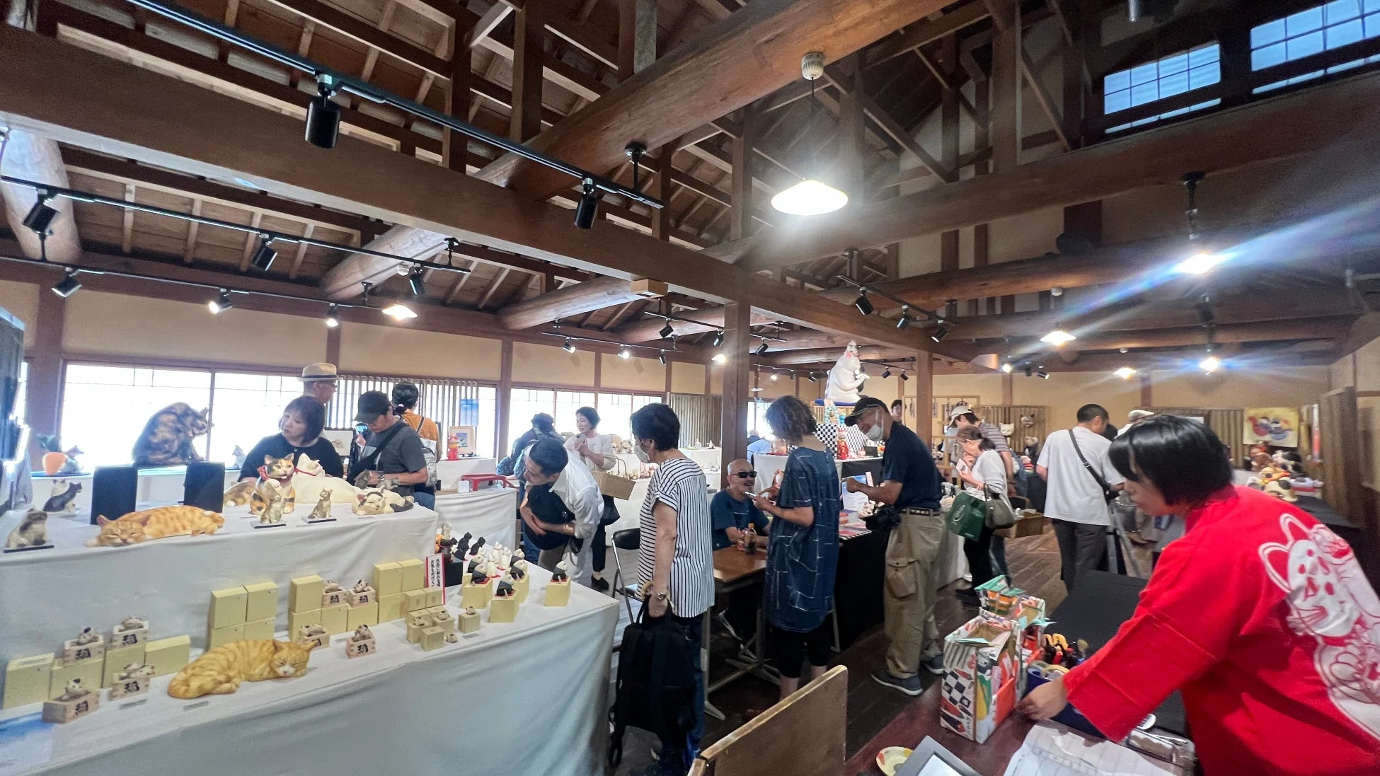 木造の建物で開催されている猫の置物やアート作品の展示販売会の様子