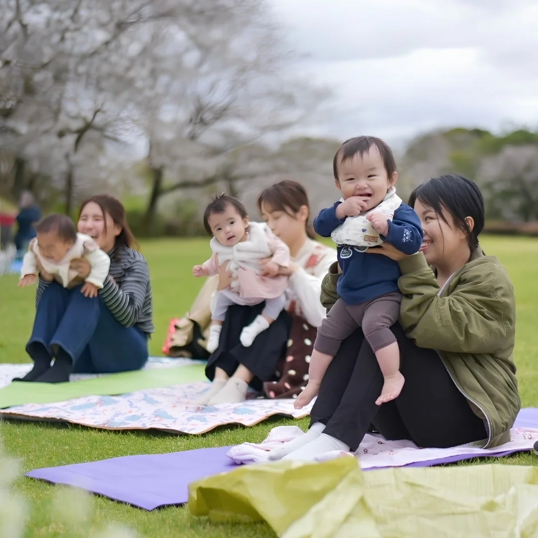 春の公園でピクニックを楽しむ親子たち