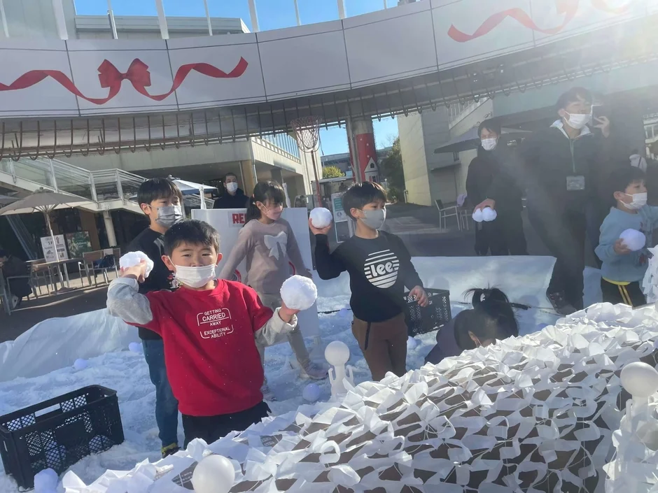 子供たちが人工雪で雪合戦を楽しむ様子