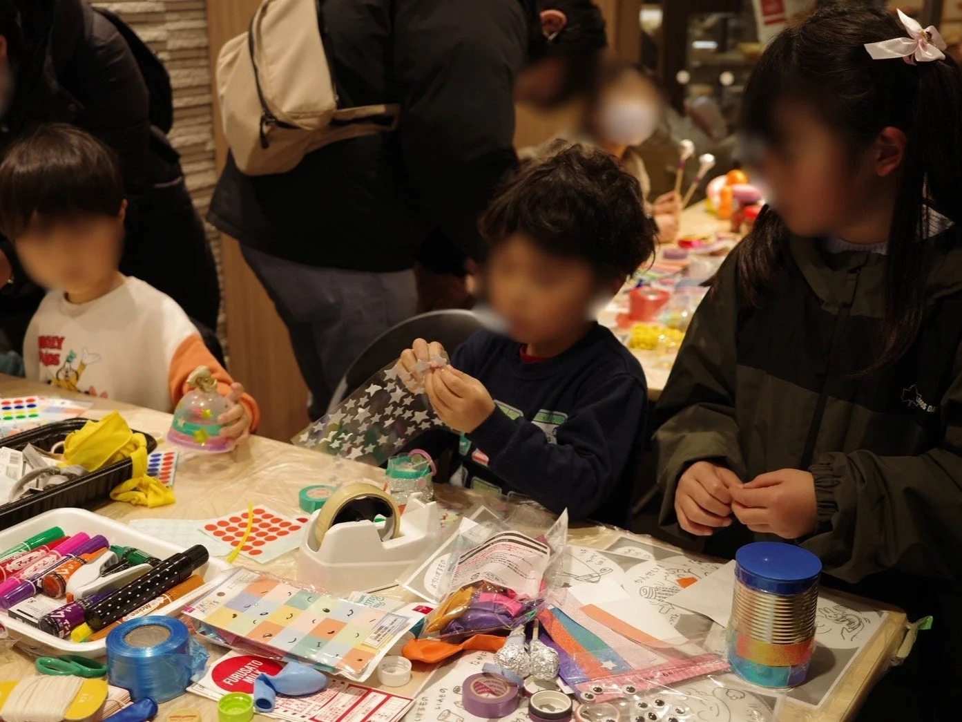 子供たちがテーブルで工作に取り組む様子