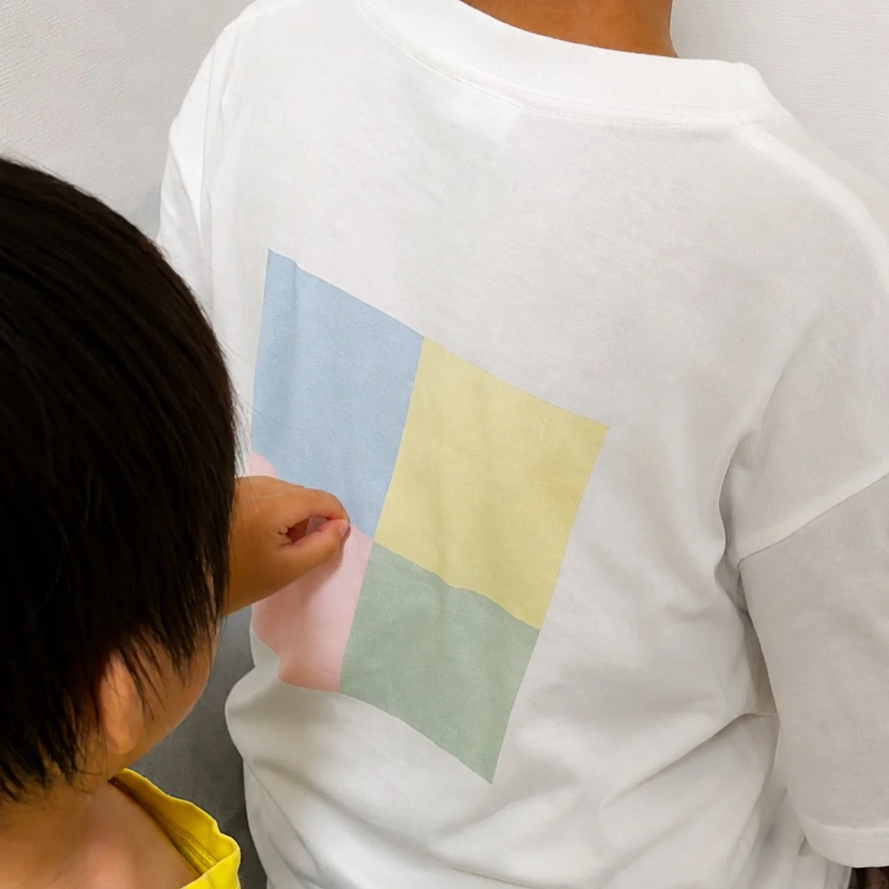 背中のマス目に触れる子供