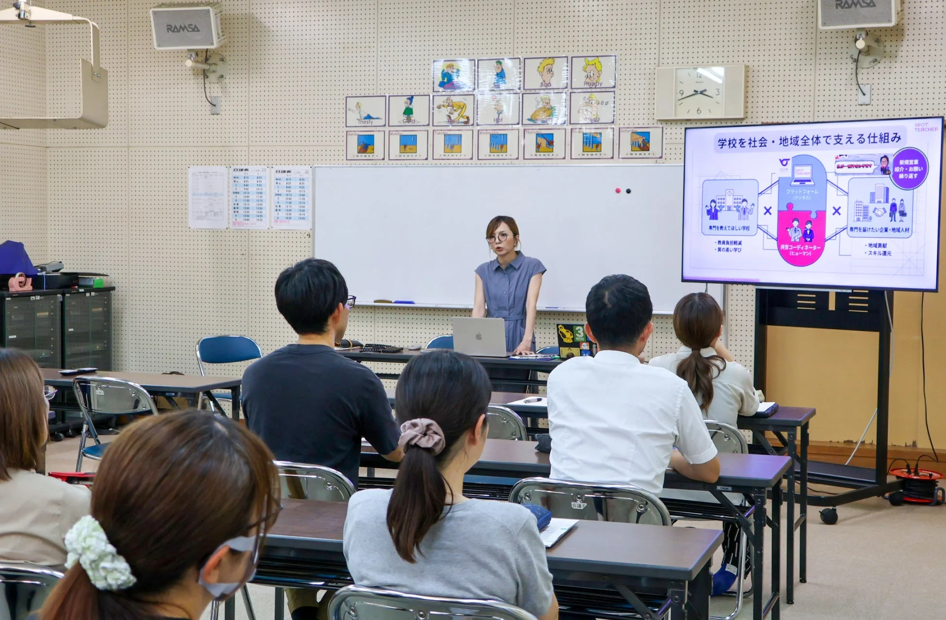 教室でプレゼンテーションをする女性講師