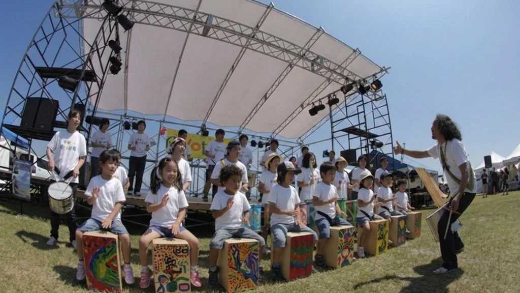 屋外でカホンを演奏する子供たち