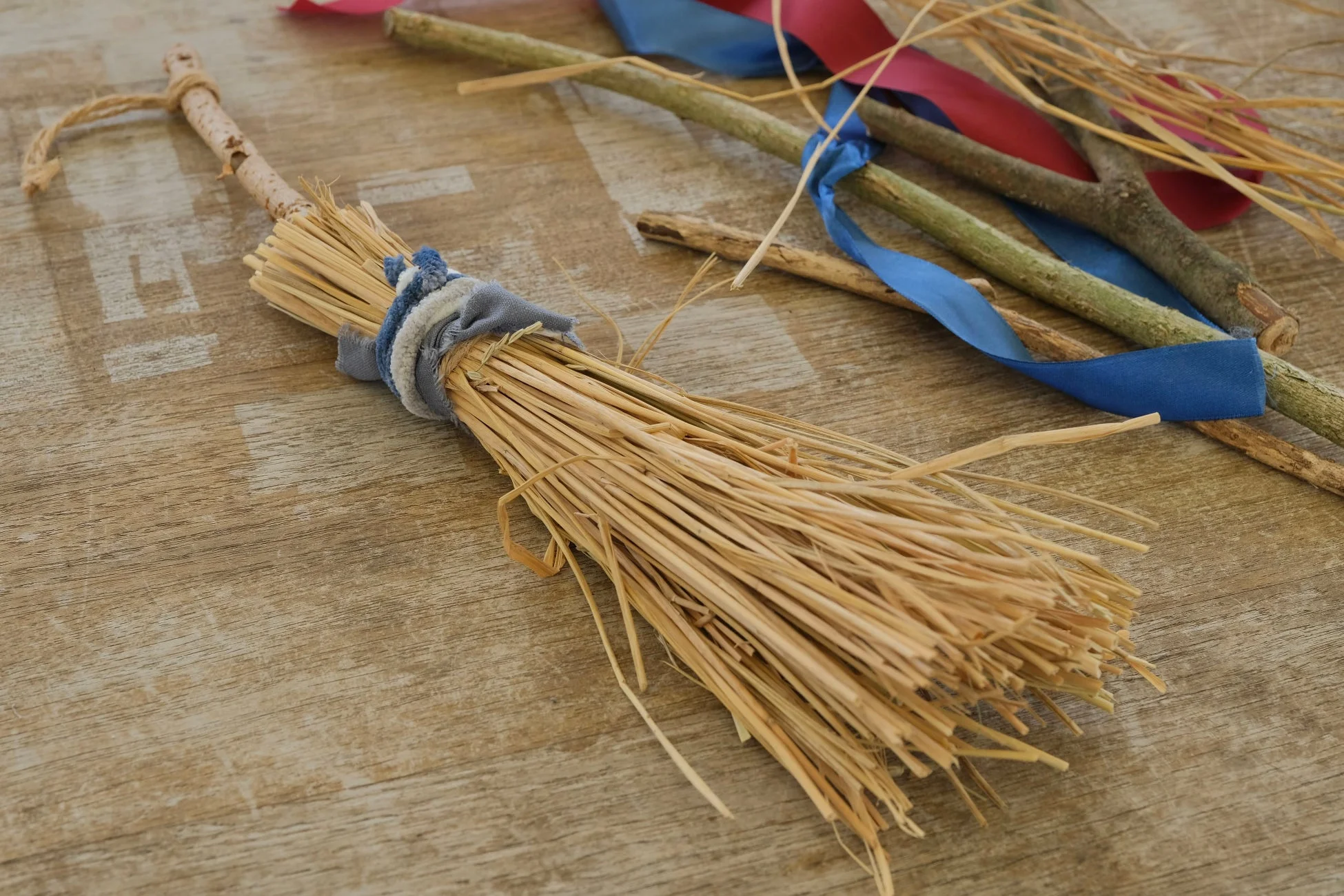 木製の柄と麦わらで作られた手作りの小さなほうき