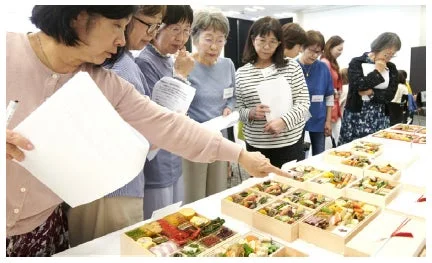 複数の女性が料理を囲み試食している様子