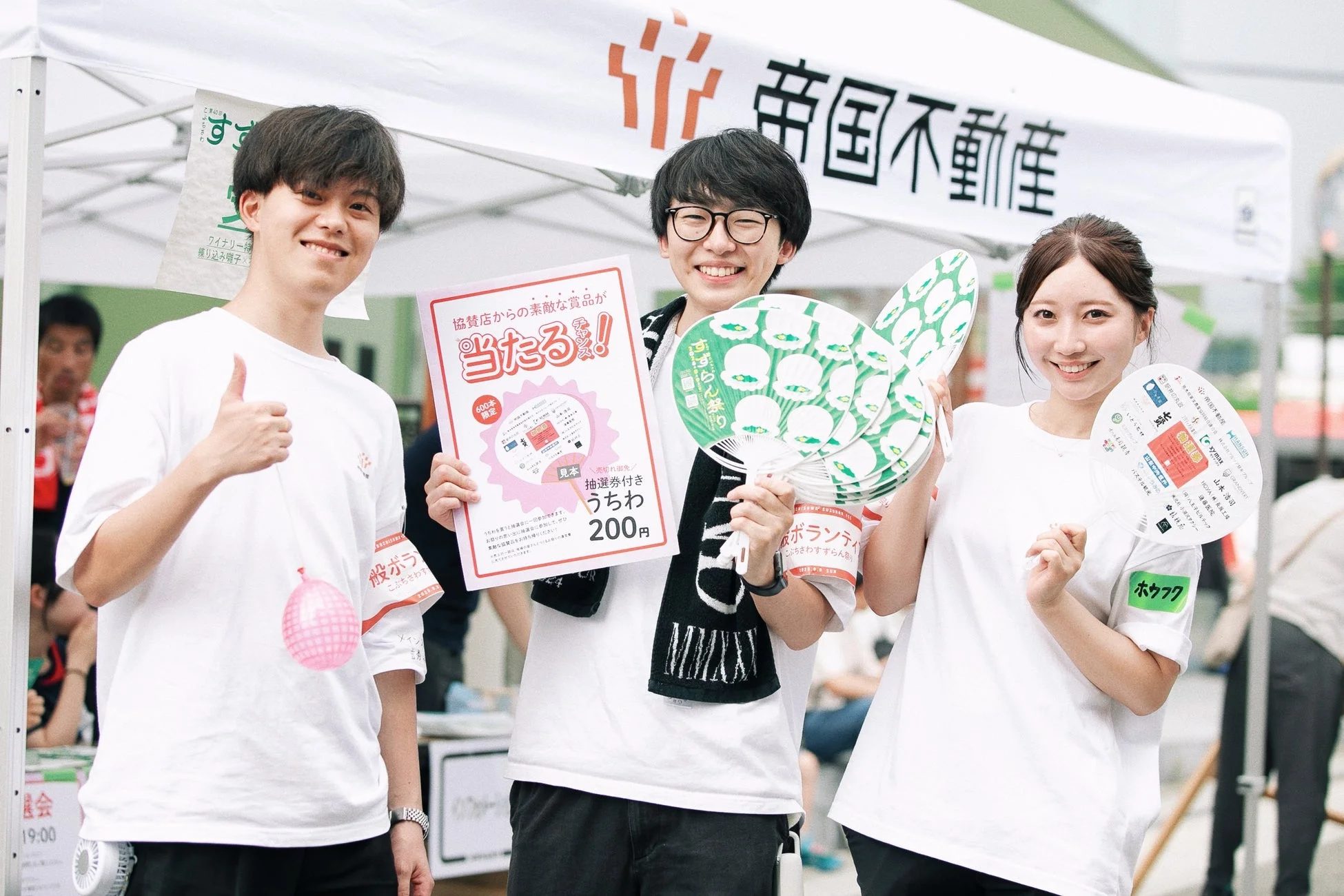 ボランティアスタッフが抽選券付きうちわを持つ様子