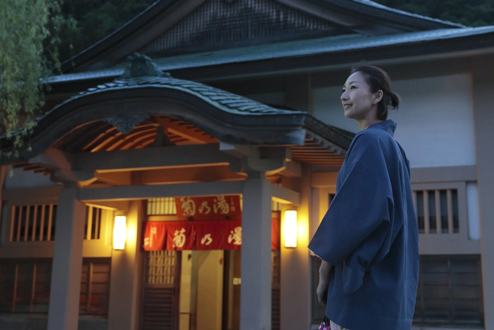 日本の伝統的な建物の前で浴衣を着た女性