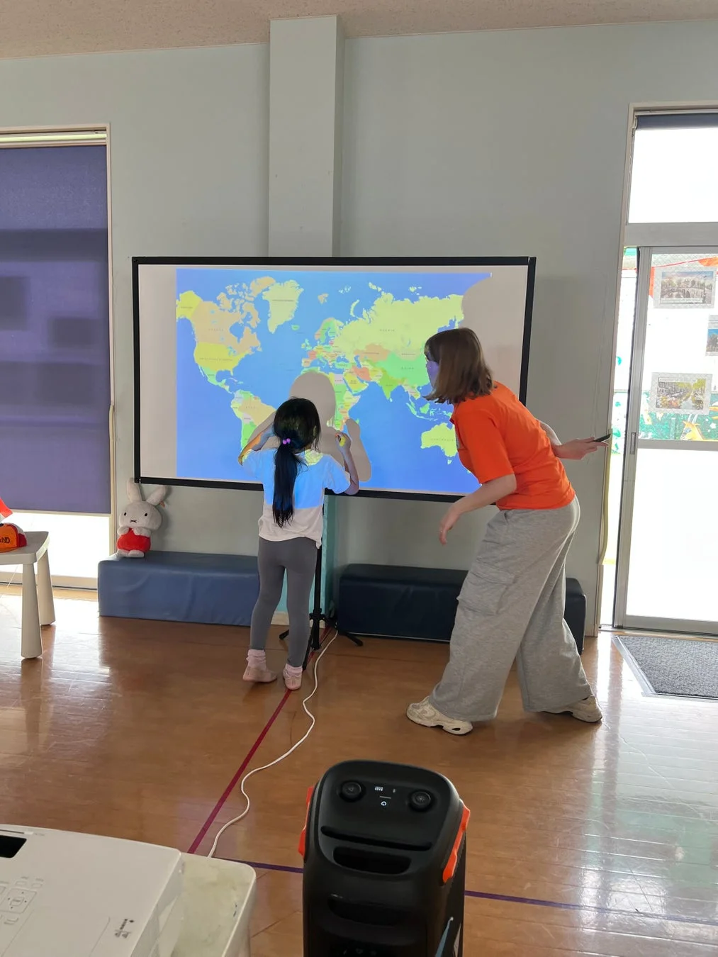 子供と大人が世界地図を見ている様子