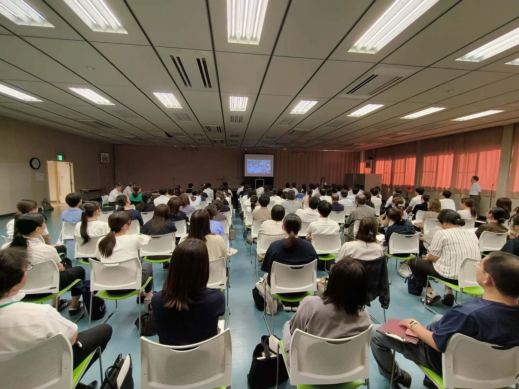 教室でプレゼンテーションを聞く人々