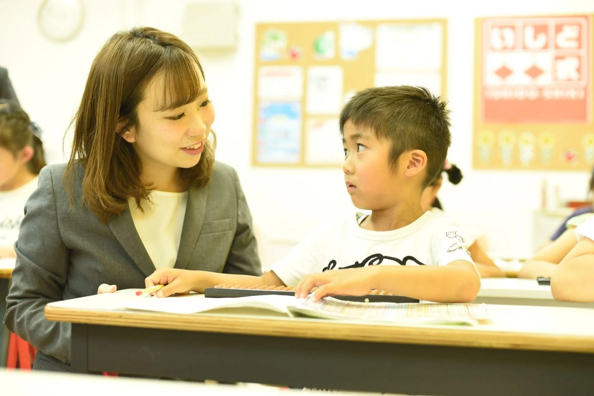 そろばんを教える先生と生徒