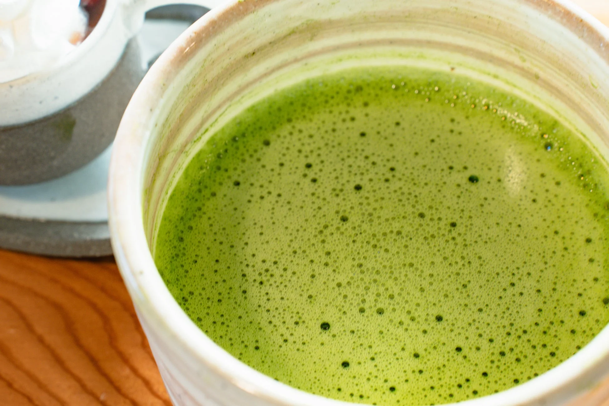 泡立った鮮やかな緑色の抹茶
