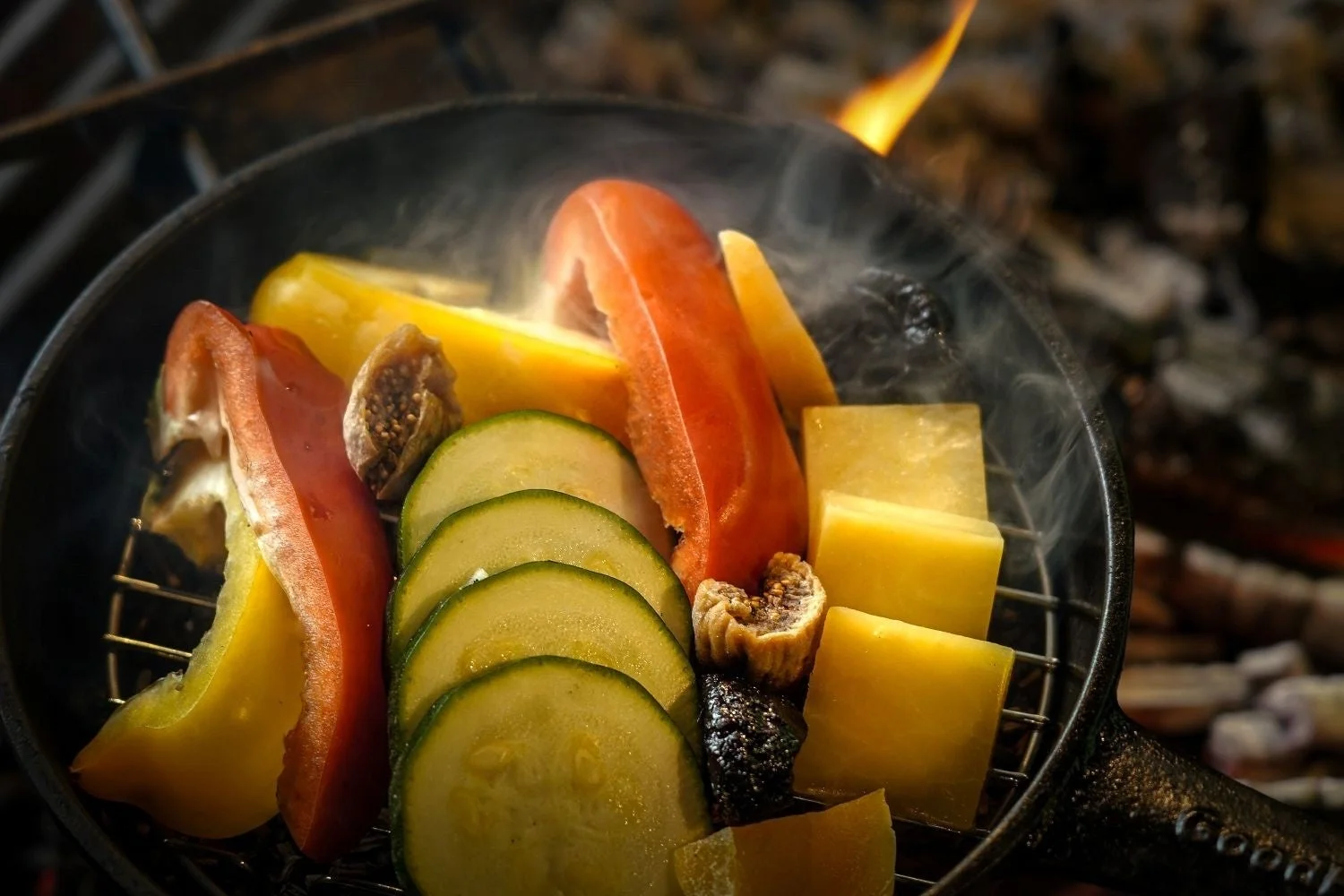 鋳鉄製のフライパンでグリルされる野菜とチーズ