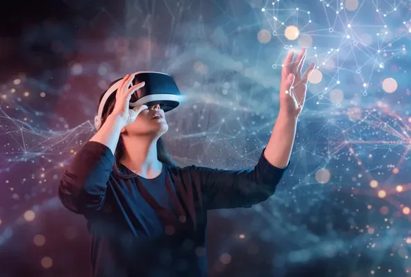 VRヘッドセットを装着した人物が、光り輝くネットワーク状の仮想空間に手を伸ばしている様子です。未来的なテクノロジーやデジタル体験、メタバースの世界観を表現しています。