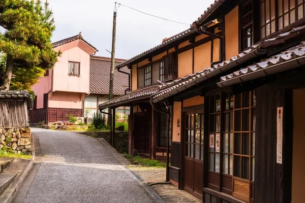 瓦屋根の伝統的な日本家屋が立ち並ぶ、趣のある路地の風景です。静かでどこか懐かしい日本の昔ながらの街並みが広がっています。