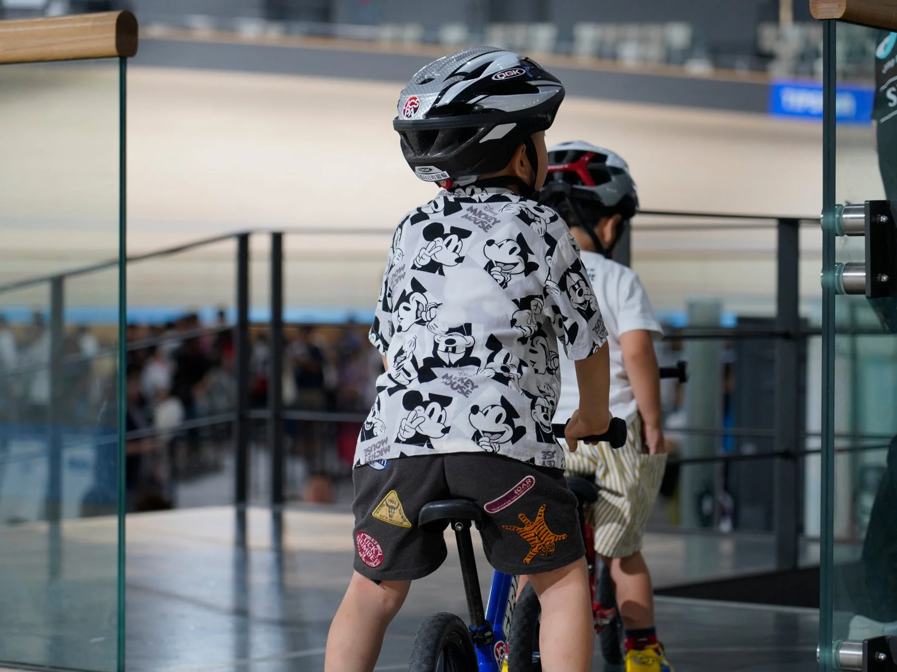 ミッキーシャツの子供が自転車に乗る