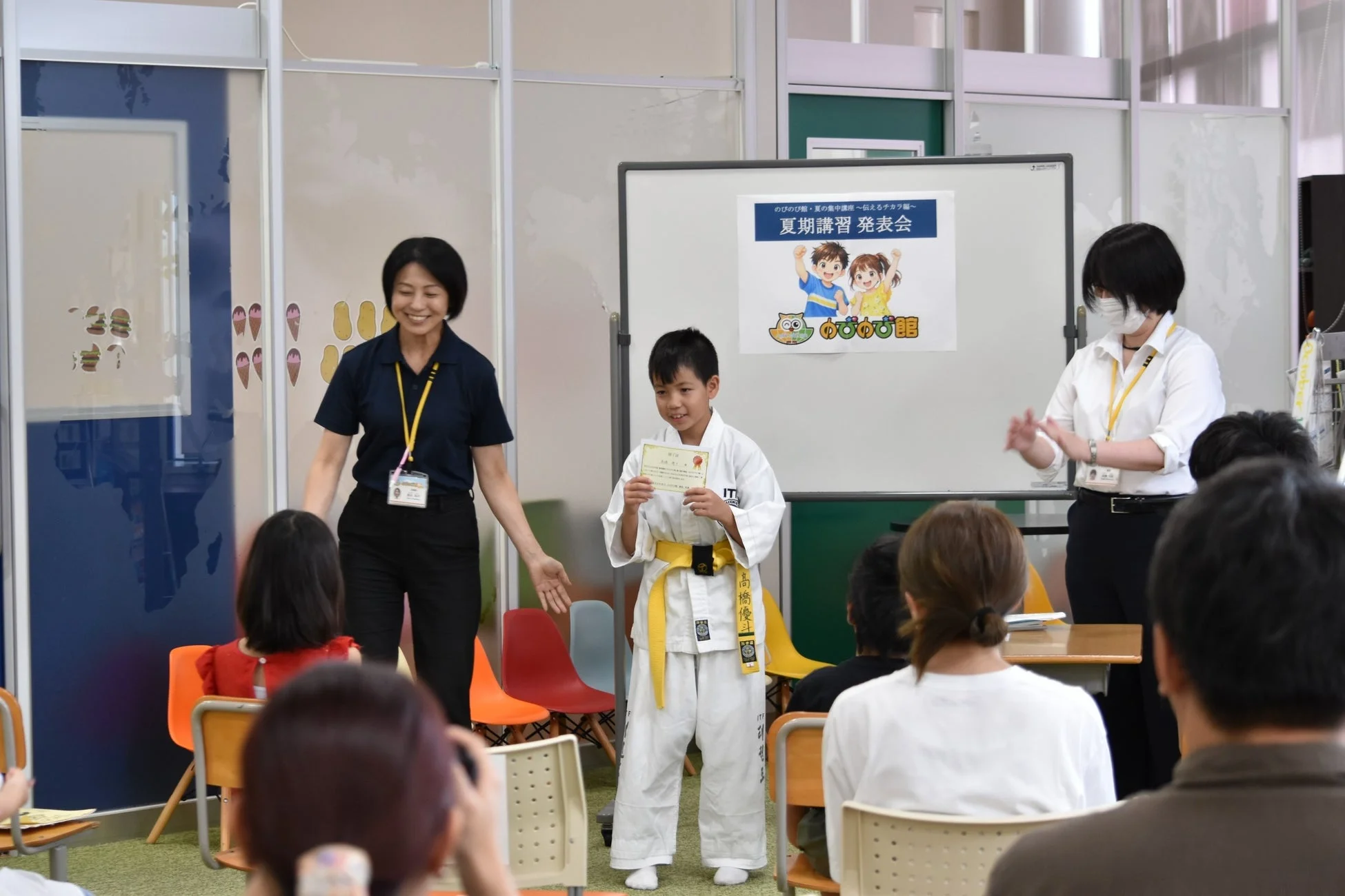 発表会で認定証を受け取る少年