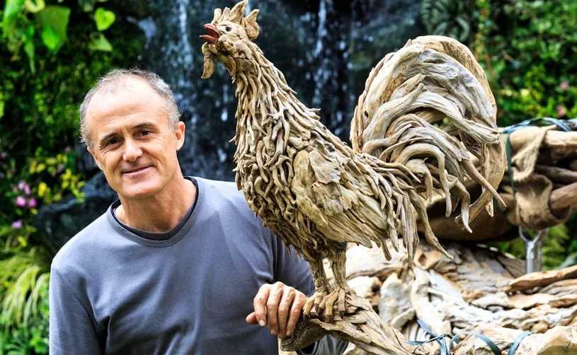 ジェームズ・ドーラン・ウェッブさんの流木アートと笑顔の男性