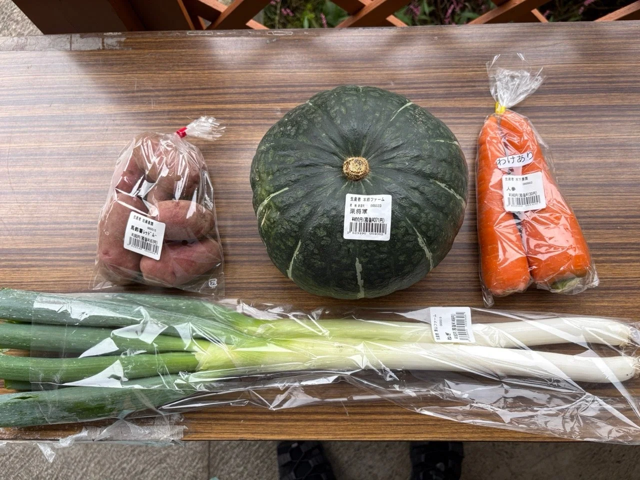 木製のテーブルに置かれた新鮮な野菜の集合写真。