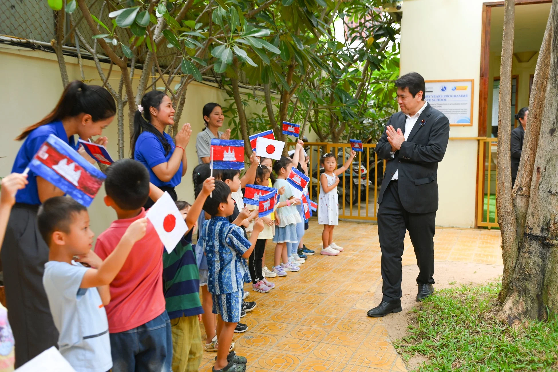 国旗を振って大臣を見送る子どもたち