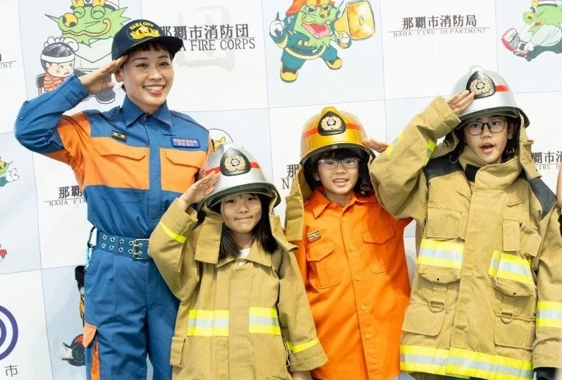 消防服を着て敬礼する子供たち